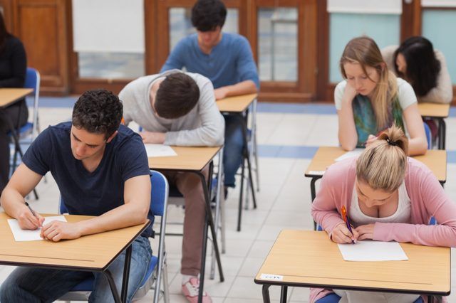 Les étudiants qui suivent le test ACT à des pupitres dans un lycée.