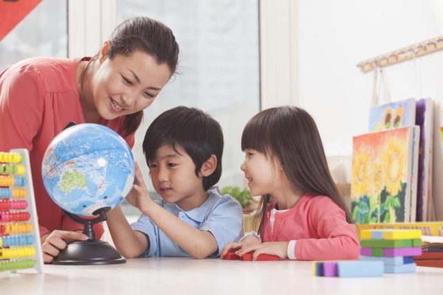 Les enfants cherchent à globe avec le professeur