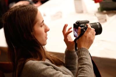 Femme regardant les images sur l'appareil photo reflex numérique