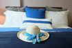 Un gros plan d'un chapeau de plage sur un lit avec diverses nuances de blues.