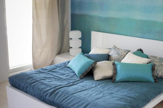 Une chambre accueillante décorée avec turquoise et de peinture aqua couleurs et linge de maison.