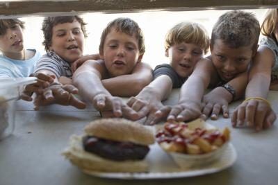 Hungry petits-ligueurs oublier les problèmes de contamination de la nourriture comme ils saisissent au hamburger et des frites.