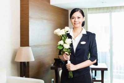 Directeur de l'Hôtel avec des fleurs et vous accueille