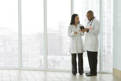 Médecins regardant tablette ensemble dans le couloir