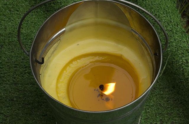 Une bougie de citronnelle allumé dans un seau combustion extérieur.