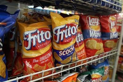 Concessionnaires vendent tacos de marche, un sac ouvert de Fritos étouffé avec des garnitures à tacos.