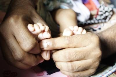 Infirmière néonatale tenant prématuré's feet