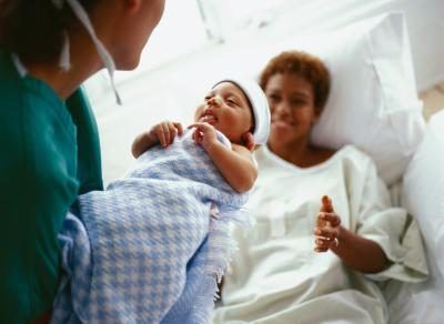 Nouveau-né en bonne santé étant portée à maman par infirmière néonatale