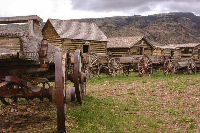 Une rangée de cabines et de wagons à un site historique le long de la piste de l'Oregon.
